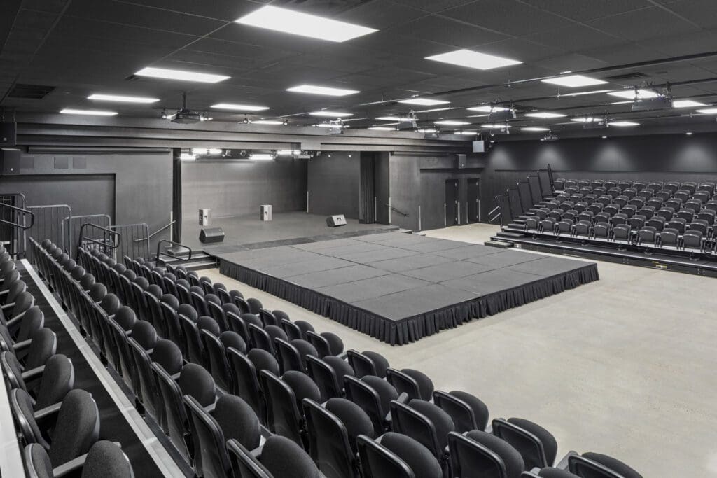 Empty modern auditorium with a stage and tiered seating at Choice Learning Academy.